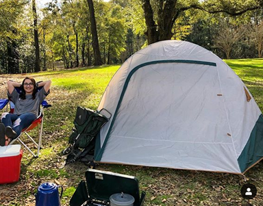 Female sitting in chair outside of tent